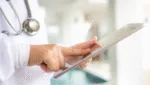 Médico utilizando um tablet em ambiente clínico, representando o uso de tecnologia no marketing para médicos de forma ética e profissional.