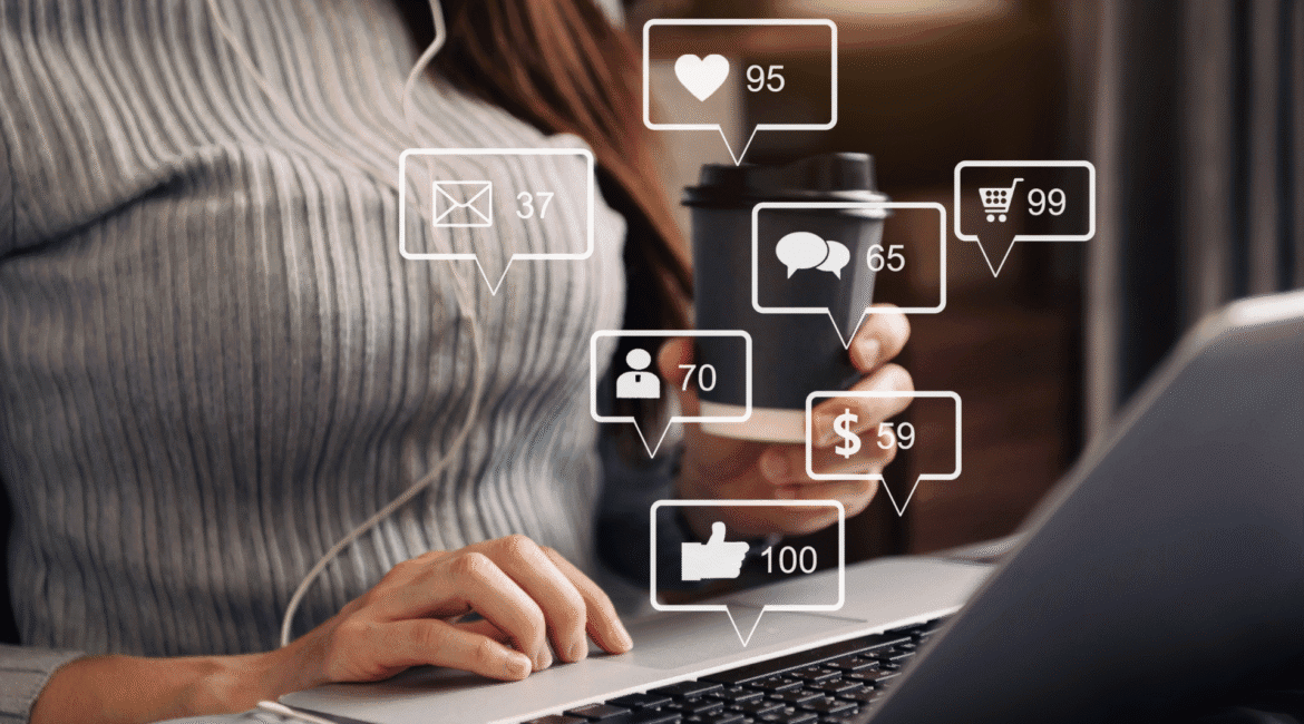 Mulher utilizando notebook com interações digitais surgindo na tela, representando estratégias de marketing de conteúdo voltadas para engajamento e conversão online.