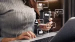 Mulher utilizando notebook com interações digitais surgindo na tela, representando estratégias de marketing de conteúdo voltadas para engajamento e conversão online.