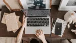 Mulher trabalhando no notebook em uma mesa organizada, representando produtividade e tendências de marketing digital para 2026.