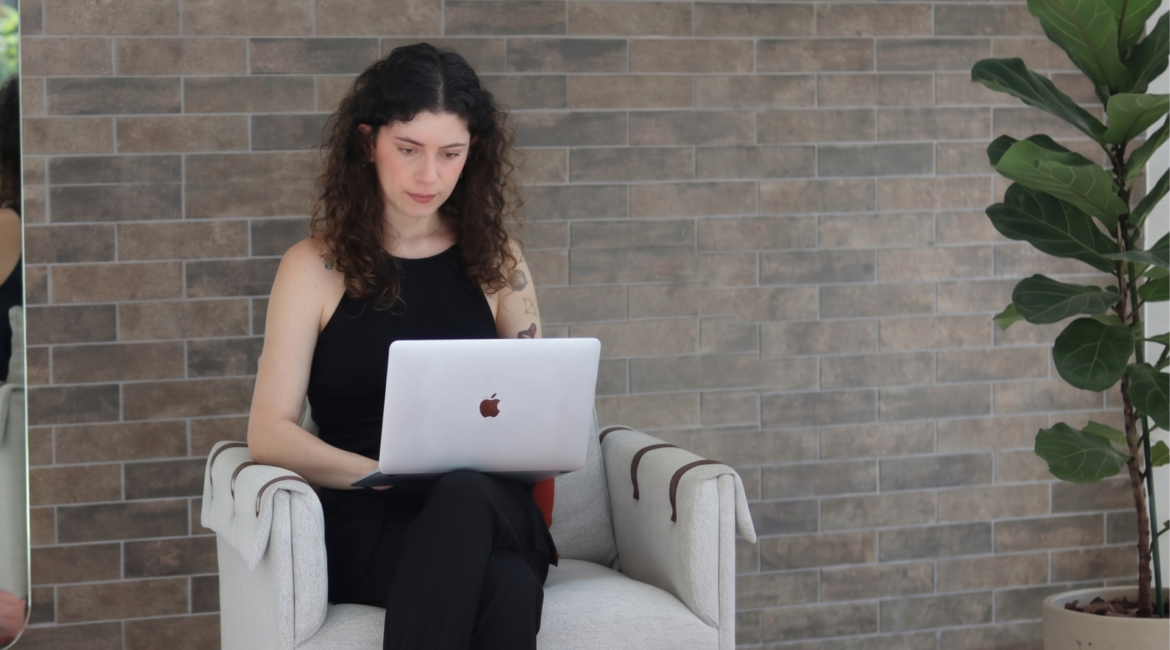 Mulher utilizando notebook em ambiente profissional, representando estratégias de SEO para IA e produção de conteúdo otimizado para buscas generativas.